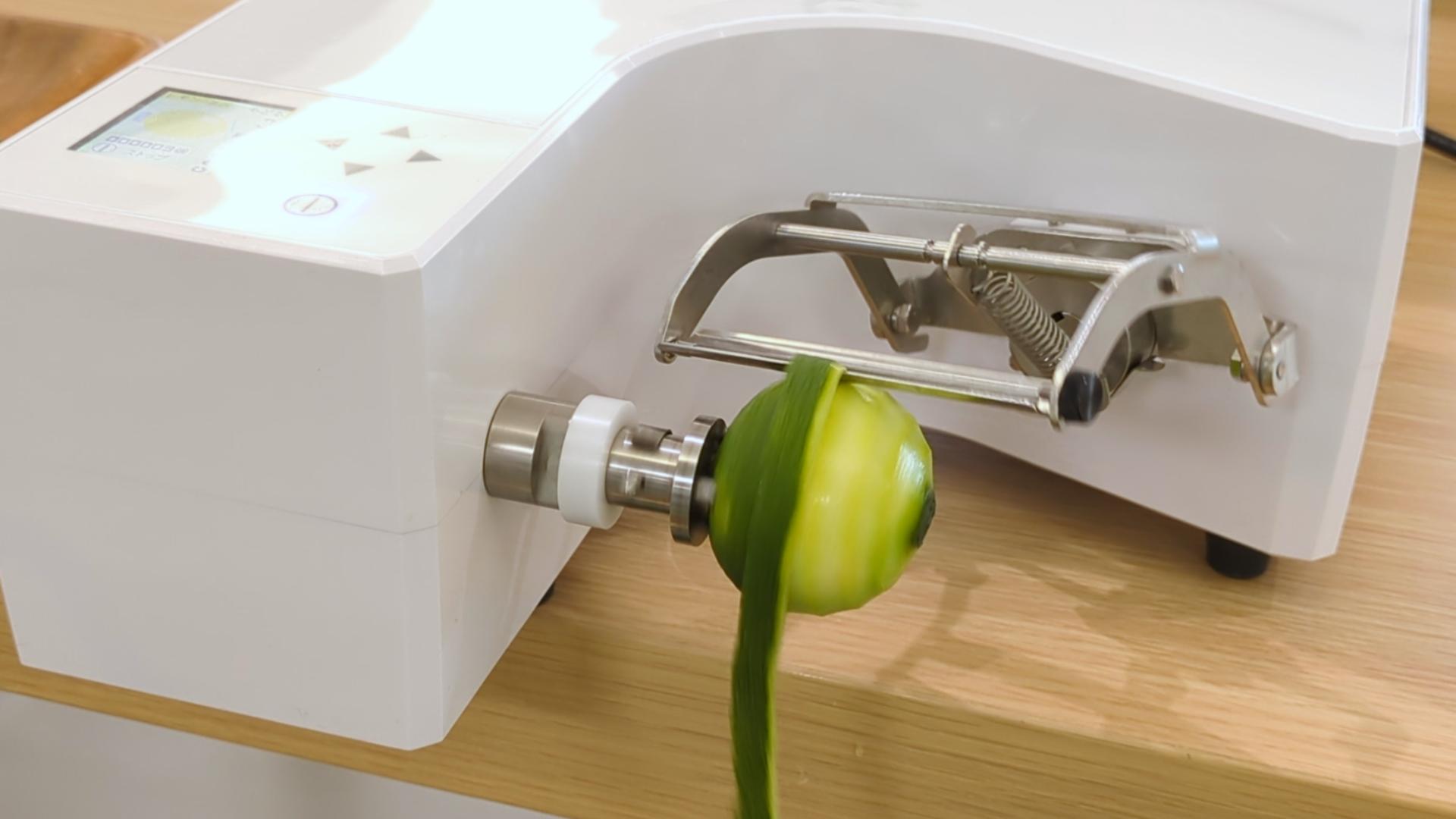 青柚子をむいている自動皮むき機